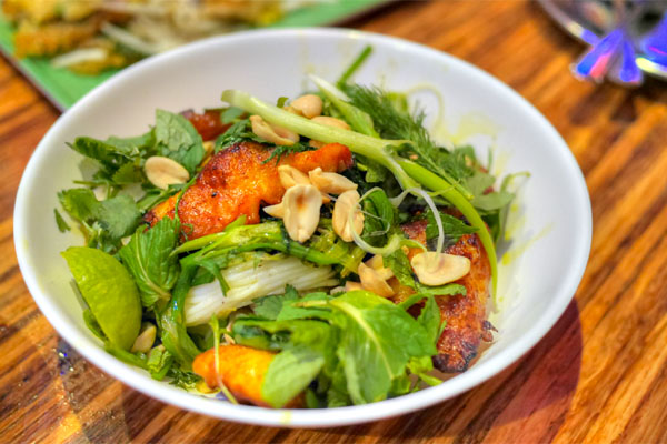 Cha Ca 'La Vong', catfish marinated in turmeric and sour rice, fried in turmeric oil with scallions and dill, served on rice vermicelli with peanuts, mint, cilantro and mam nem