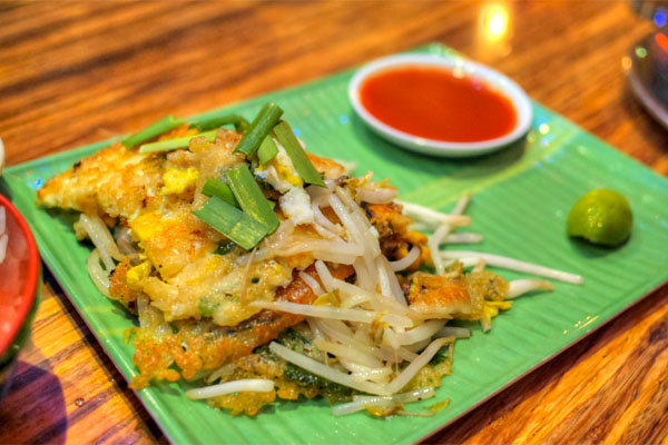 Hoi Thawt, crispy broken crepe with steamed fresh mussels, eggs, garlic, chives and bean sprouts, served with Shark Sri Racha sauce