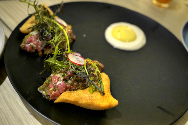 Steak and oyster tartare with champagne sabayon and bone marrow beignets