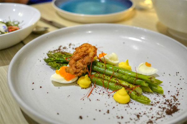 Asparagus with deviled egg purée, fried oyster and black bread