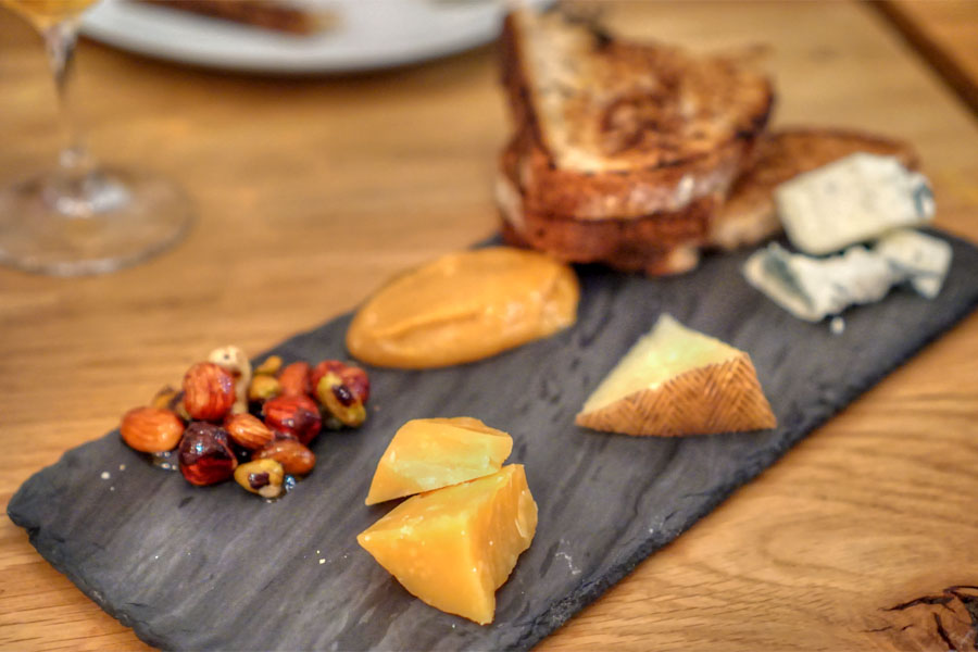 selection of cheeses with ginger-persimmon jam, nuts, honey, and griddled bread