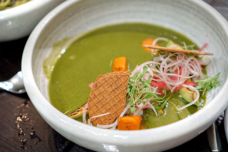 Green tomato 'pozole' with hearts of palm, hominy, sweet potato, avocado, pomegranate and blue corn pizzelle