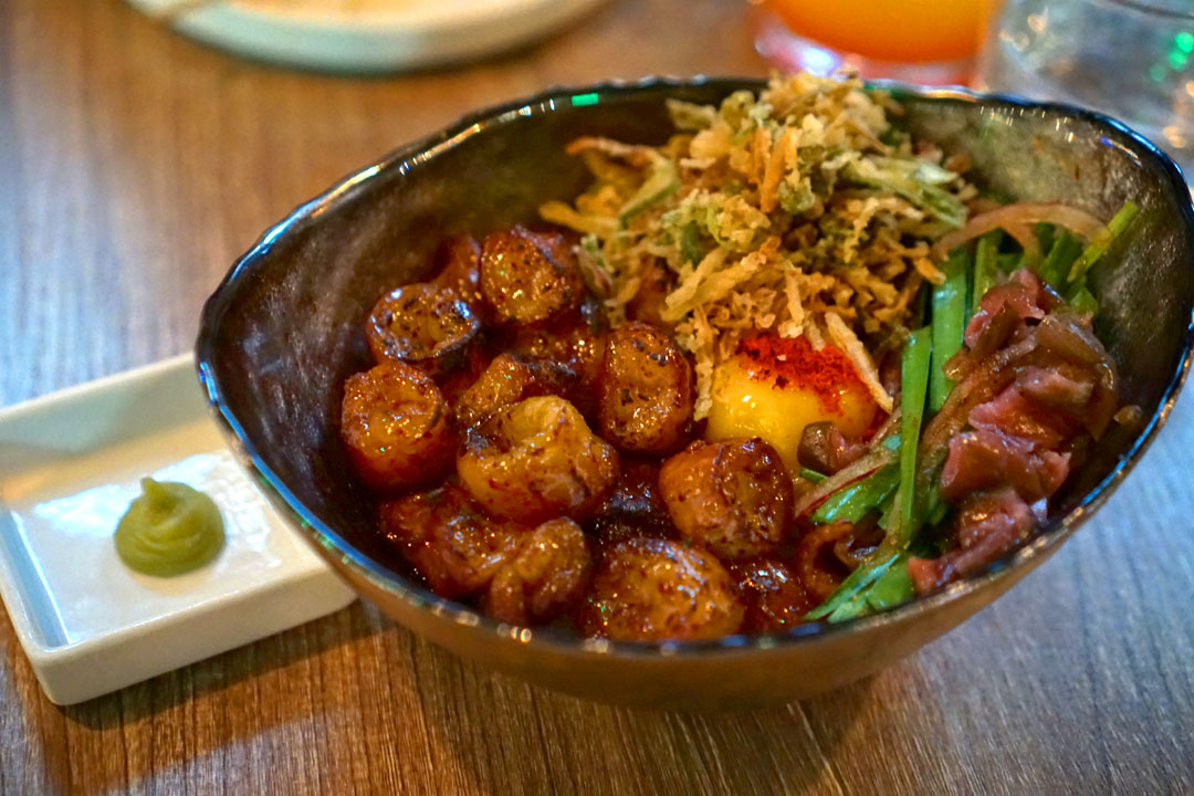 Dae-chang (beef intestine) over rice, soy glazed marinated intestines, tomatillo salsa, egg yolk, side of wasabi