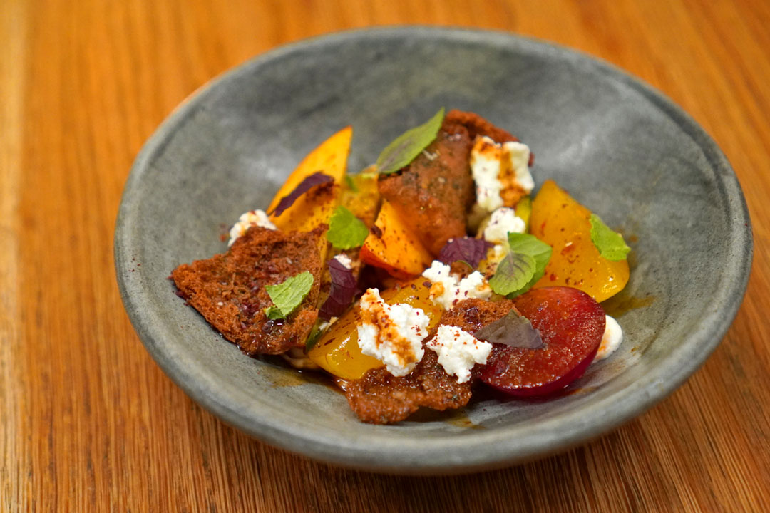 Stone fruit fattoush, salted cucumber + harissa vinaigrette + smoked feta