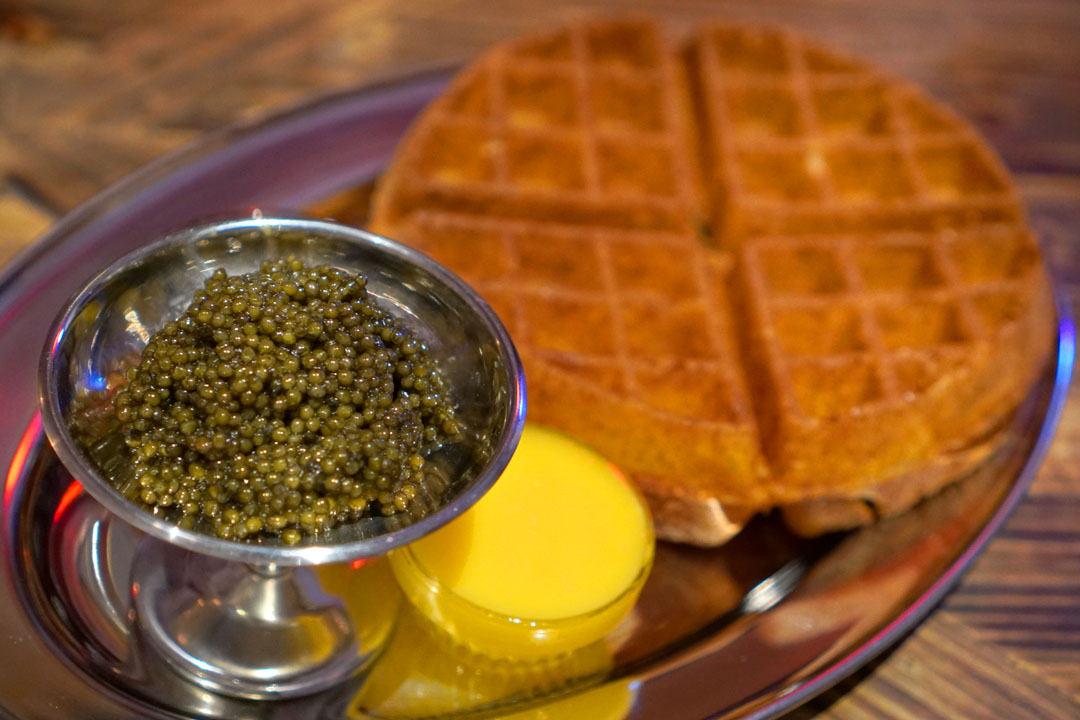 Our ossetra caviar cured with country bacon salt & aged for 6 months, red flint polenta waffle; barbecue corn cob maple syrup & Bordier butter