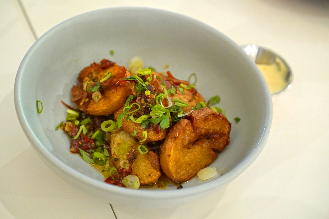 'Secret' Potatoes, smashed Weiser Farms potatoes, aromatic chili cumin butter, chili crisp, scallion, cilantro