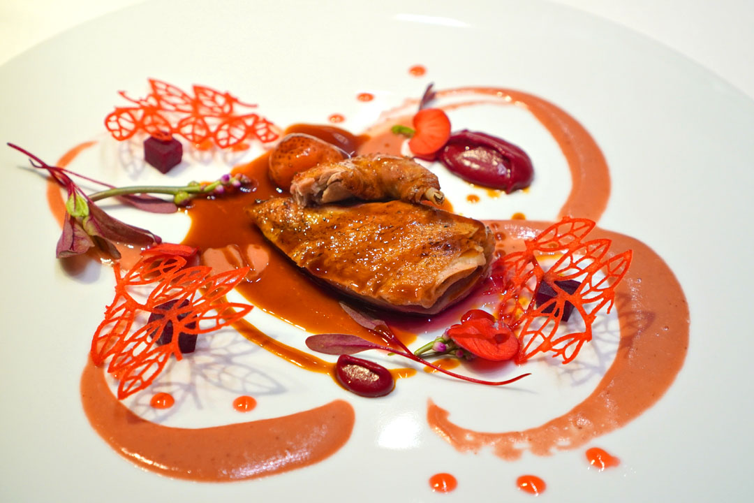 Miso-marinated pigeon with annatto and pink pepper, beetroot romesco, pickled strawberries with crispy kimchi and roses